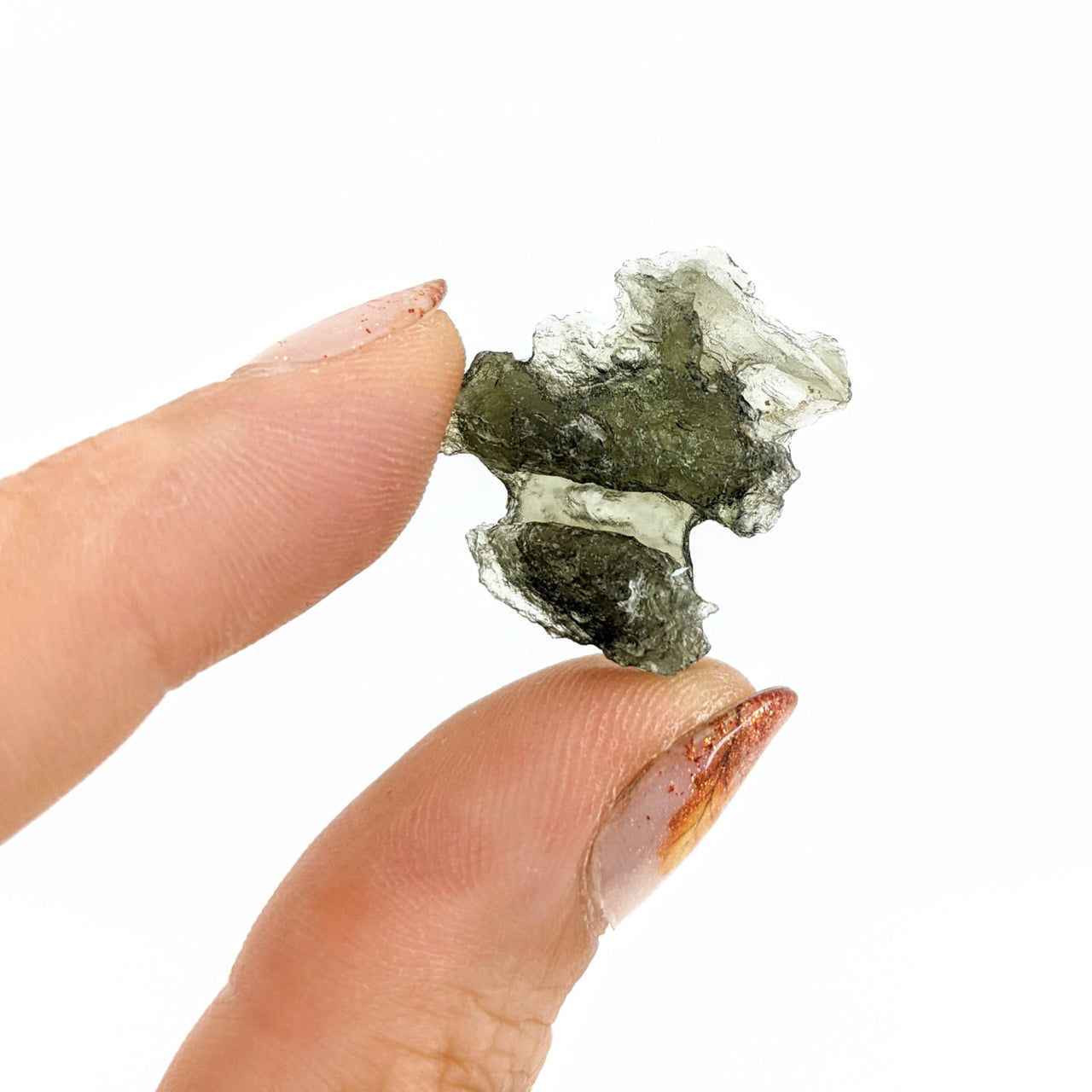 A hand holding Moldavite Raw Besednice from the Czech Republic, product #SK0565