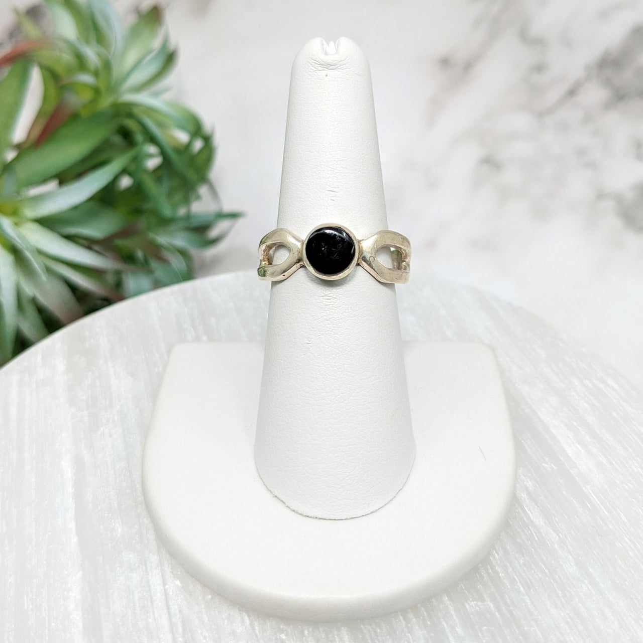 Moldavite Sz 10 Polished Round Ring, black stone on white pedestal, model #LV5113