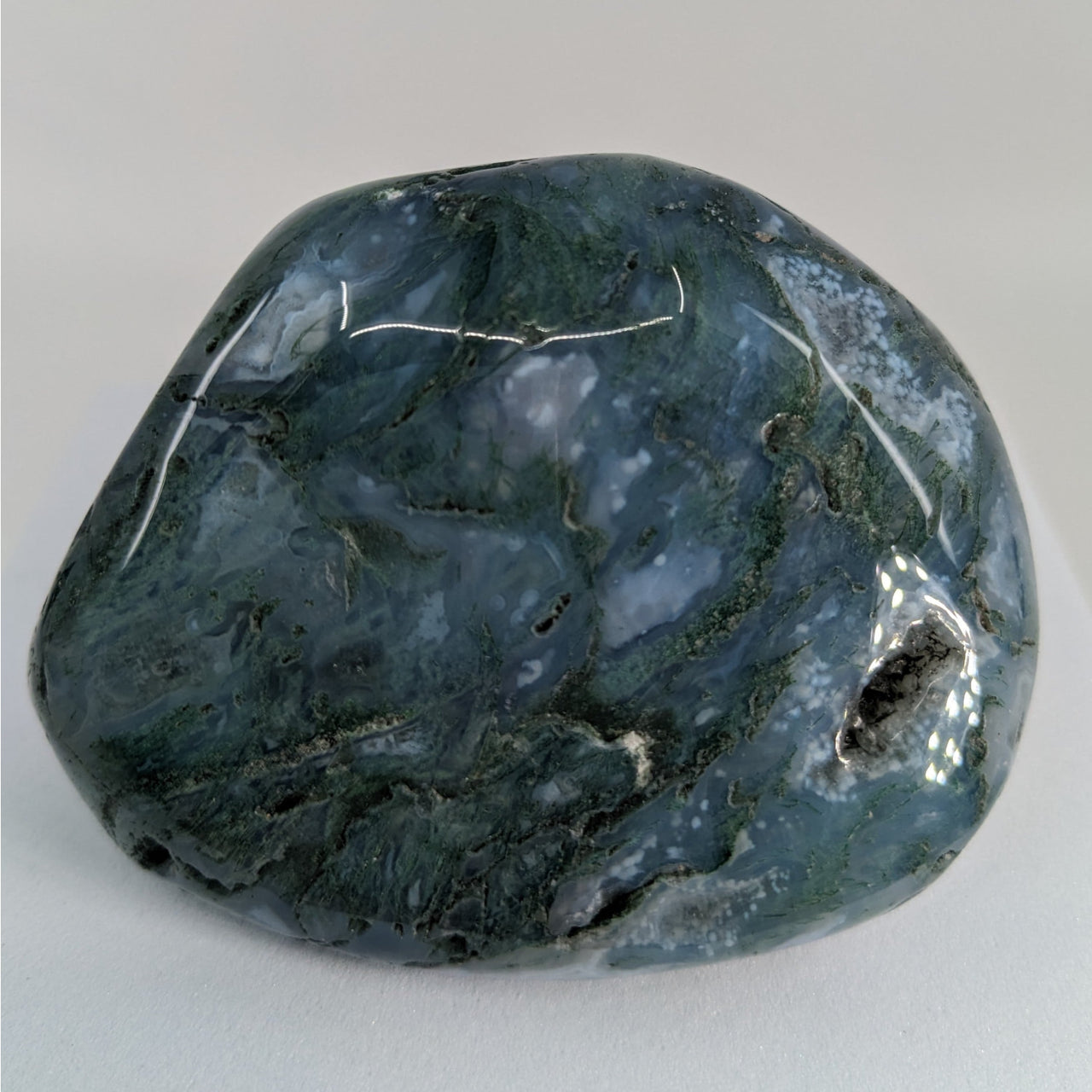 A large green Moss Agate stone on a white background - Moss Agate Touchstones #P165