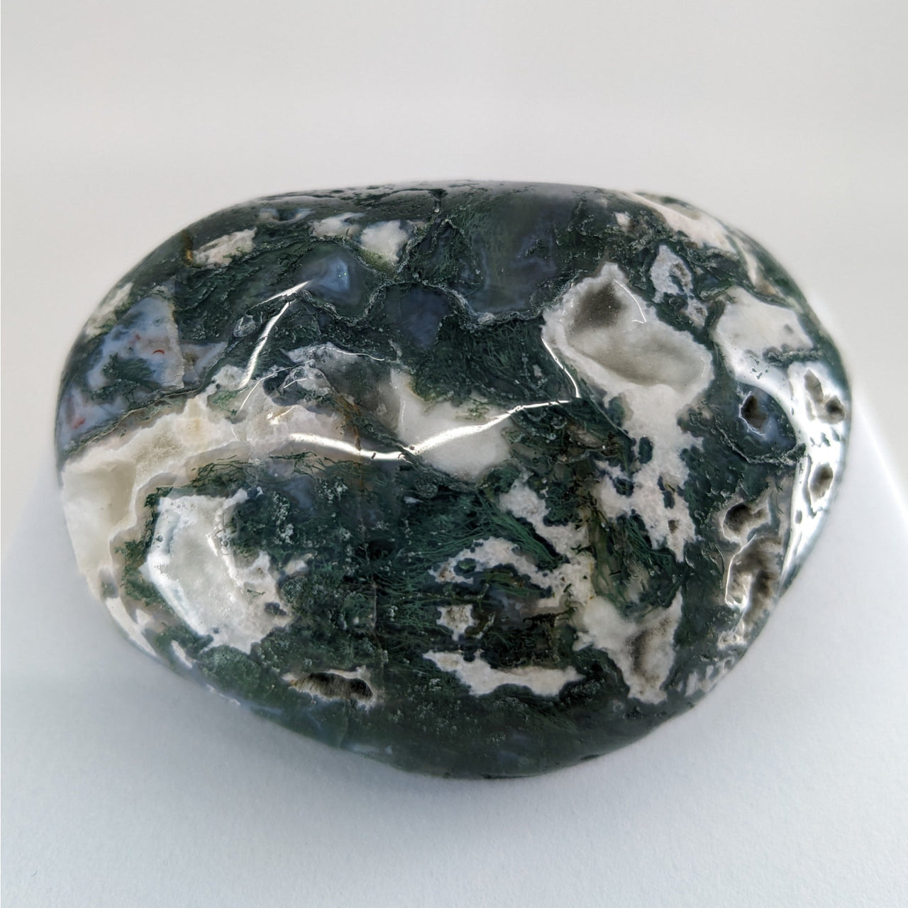 Large black and white marble sphere displayed in Moss Agate Touchstones #P165