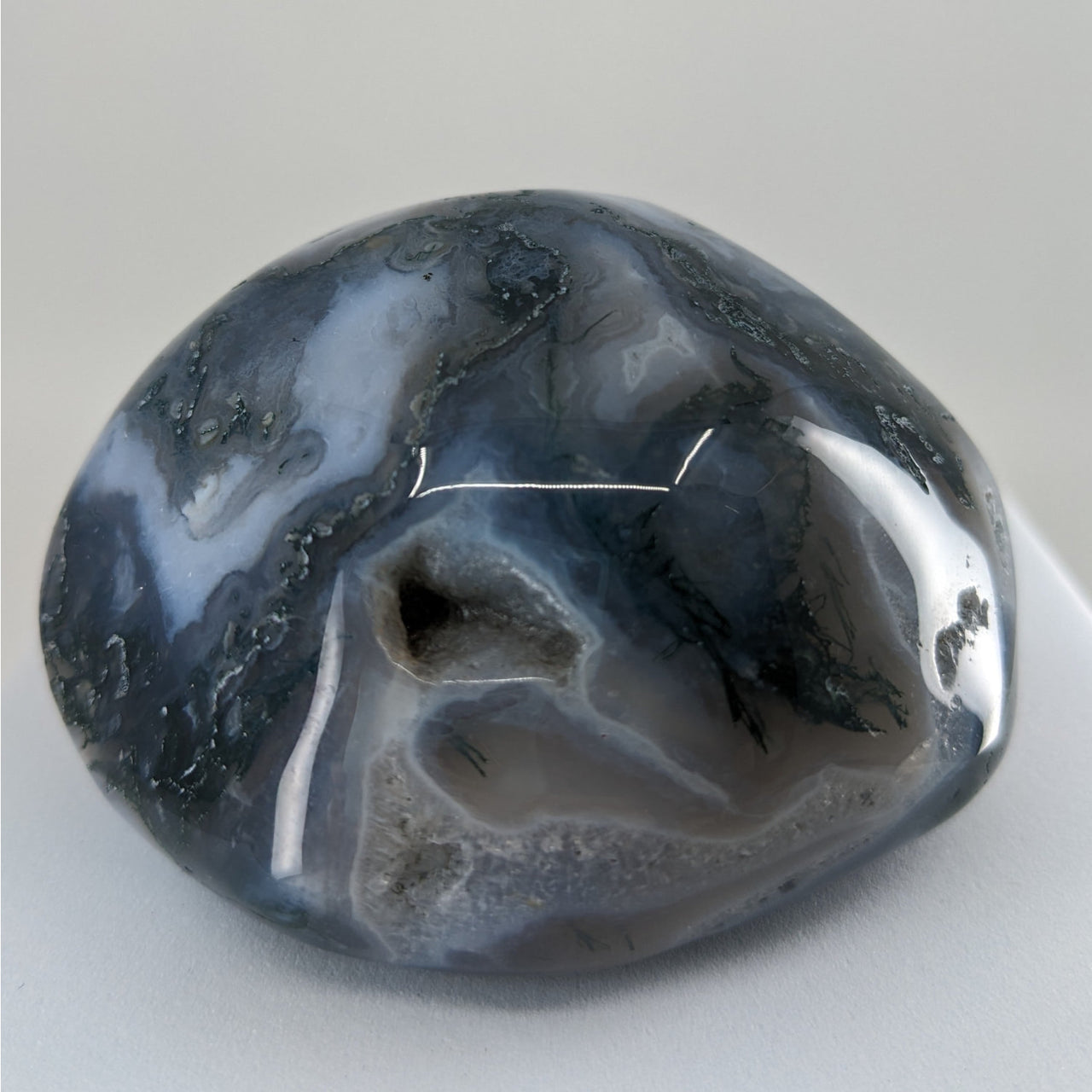 Large blue and black Moss Agate Touchstone displayed on a white background