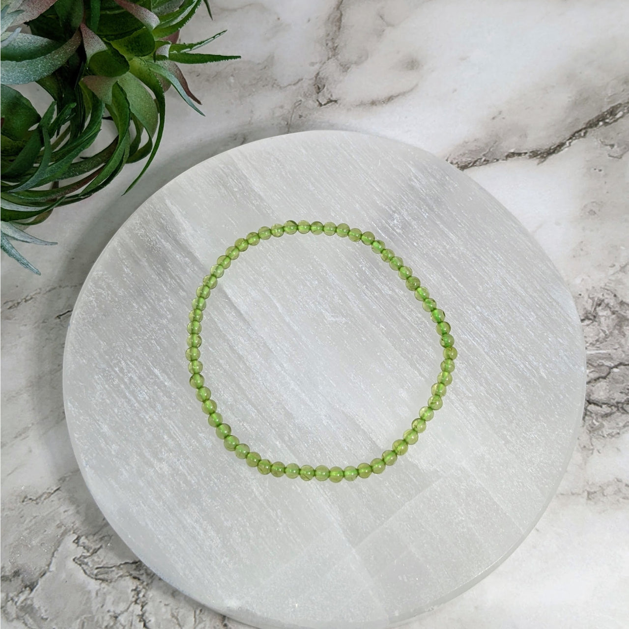 White marble tray with a Peridot 7’ green beaded bracelet, 3mm #LV4042