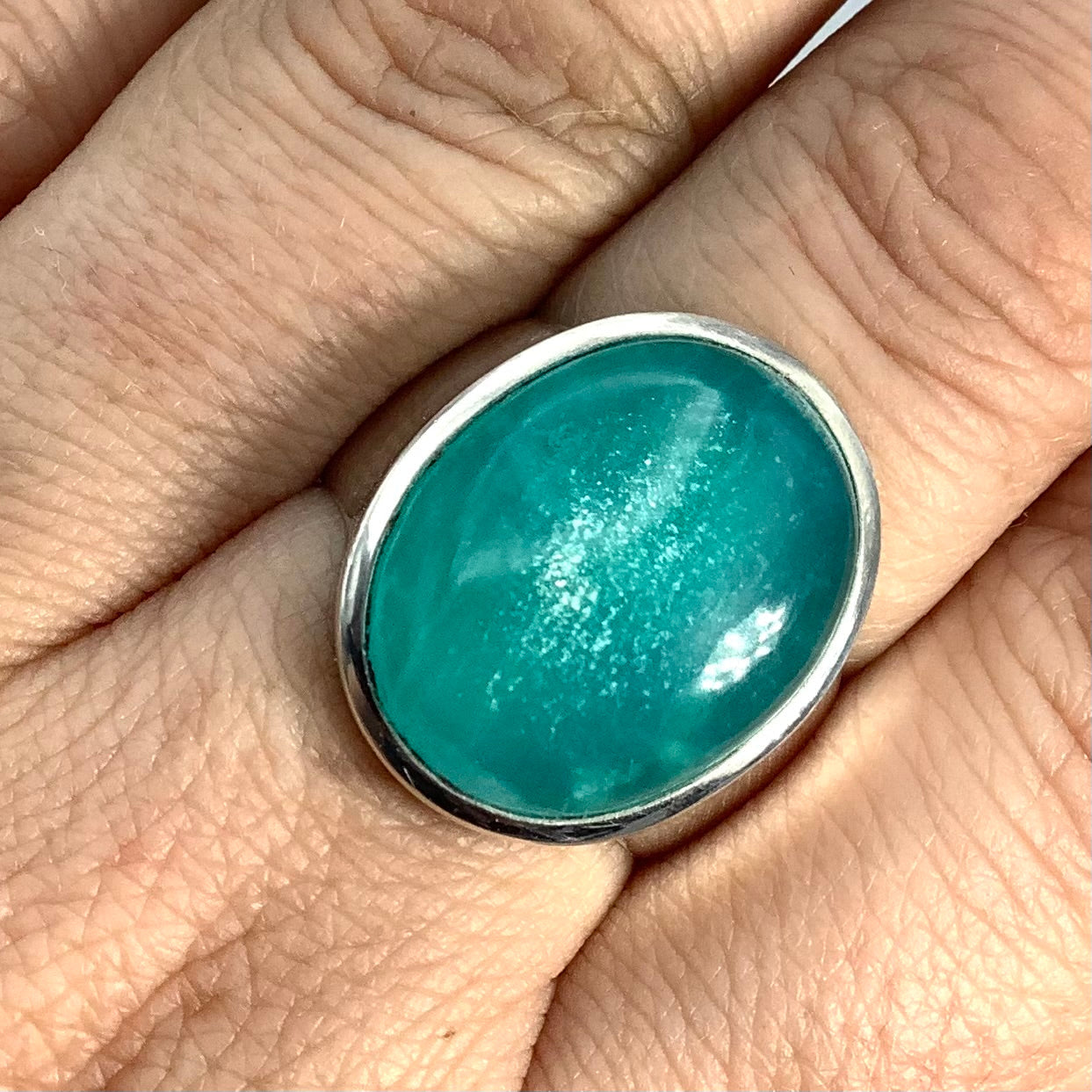 Woman’s hand holding a green Peru Amazonite Ring Sz 7.5 #SK2612