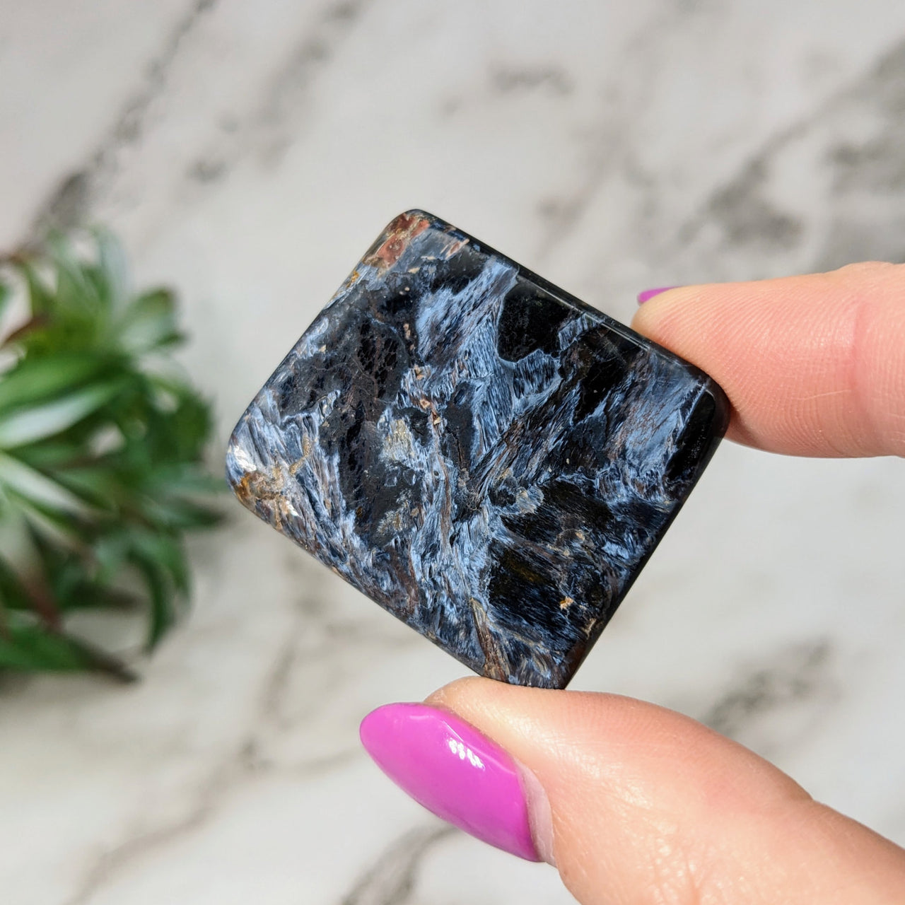 A person holding Pietersite 1.4’ flat marble block - Polished Slice #LV5082 black and white