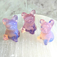 Thumbnail for Three pink opalite glass pig figurines on a table from ’Pink Opalite 1.2’ French Bulldog Carving #LV2312’