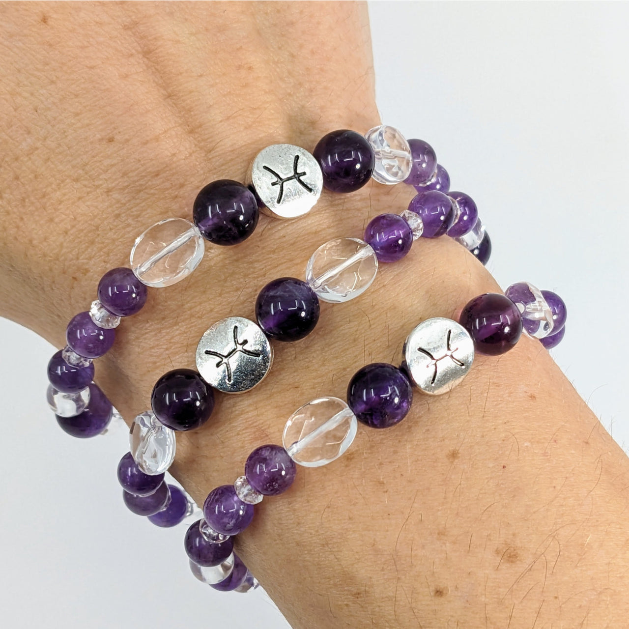 A woman’s hand wearing the Pisces Zodiac Handmade Beaded Bracelet