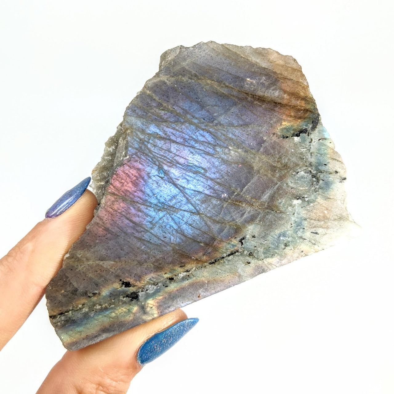 A hand holding a Purple Labradorite Half Polished, Half Rough Stone with rainbow colors #SK8963