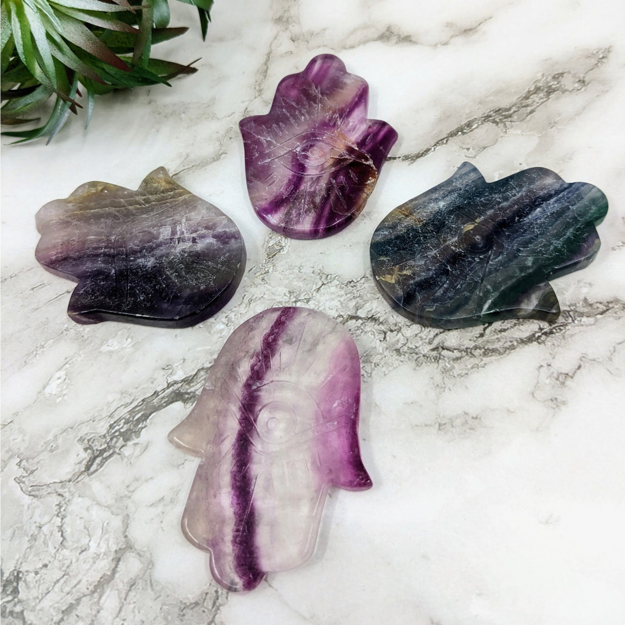 Rainbow Fluorite Hamsa #LV4224 with three amethyst crystals on a marble table