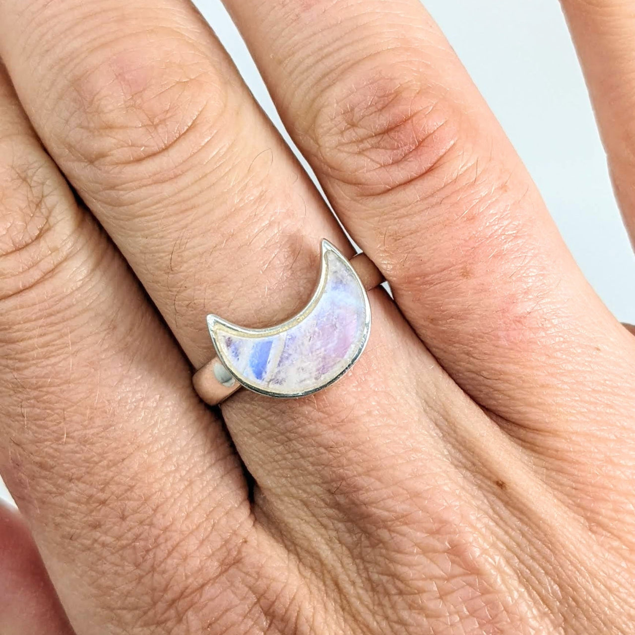 Person holding Rainbow Moonstone Crescent Moon Sterling Silver Ring #J678D