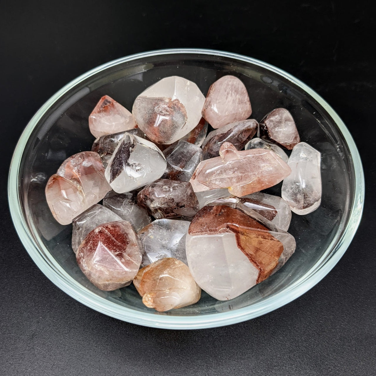 A bowl of Red Phantom Quartz tumbled stones, perfect for crystal collectors