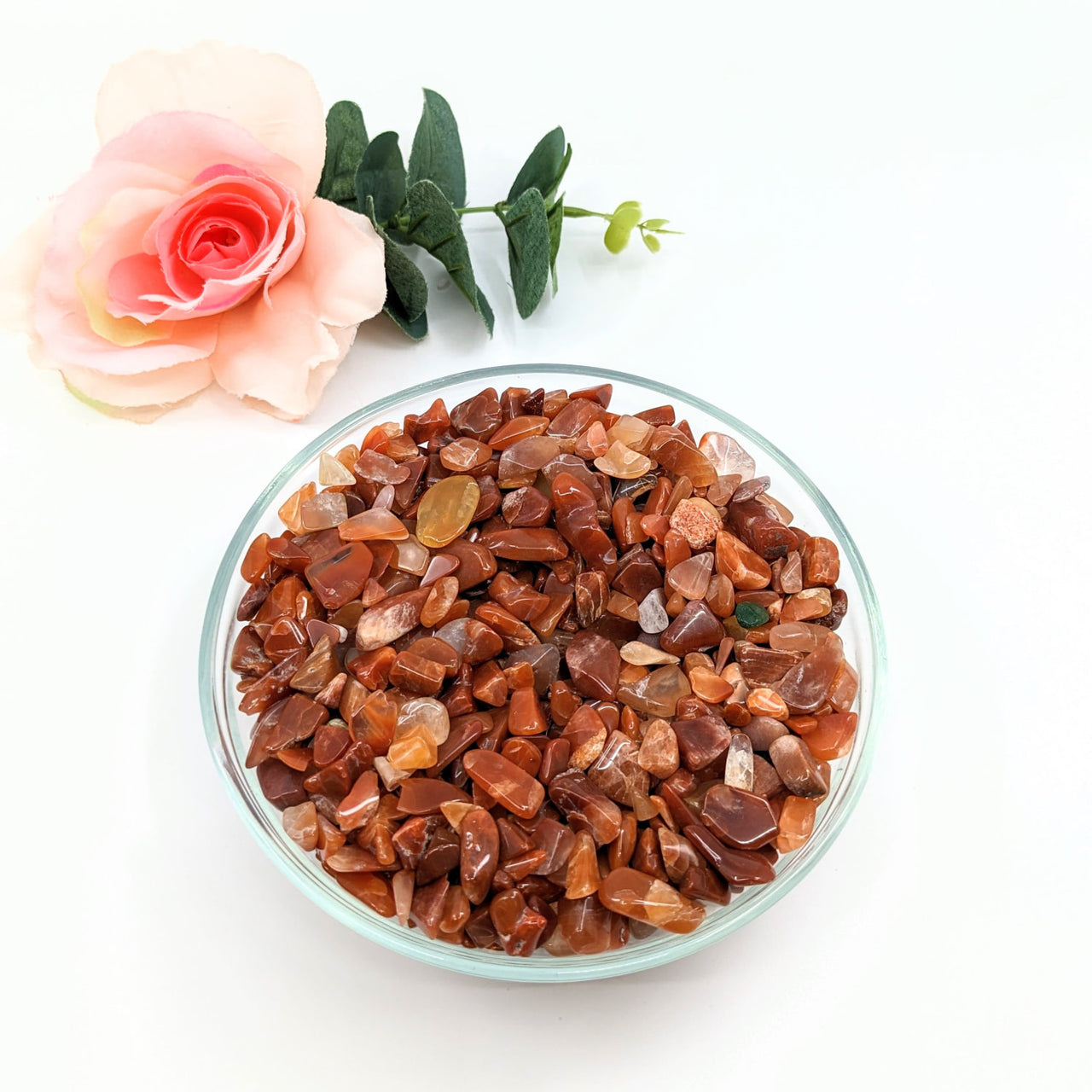 Red Quartz Gravel Mini Chips 28g Parcel (#LV3079) in a Bowl with Rose Decor on Table