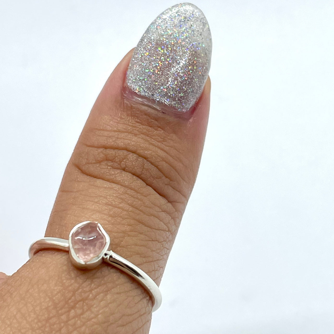 A woman’s hand wearing a Rose Quartz Natural Dainty Stackable Sterling Silver Ring #J022