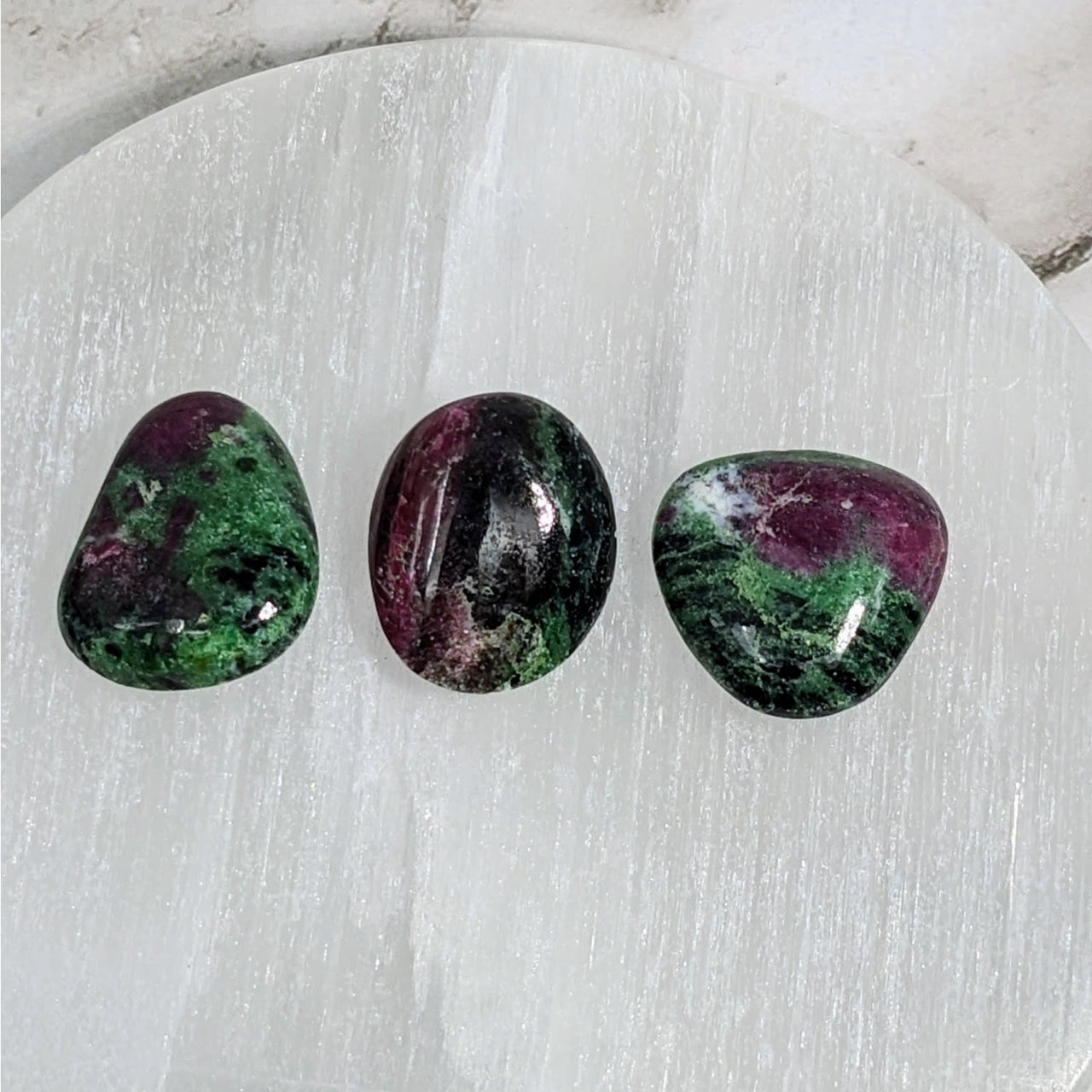 Three green and purple tumbled stone earrings on white marble plate, Ruby Zoisite LV4056