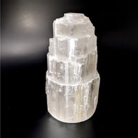 Thumbnail for Close-up of Selenite 5.7’ Rough Tower Lamp on a black surface with bulb and cord, product #LV4140