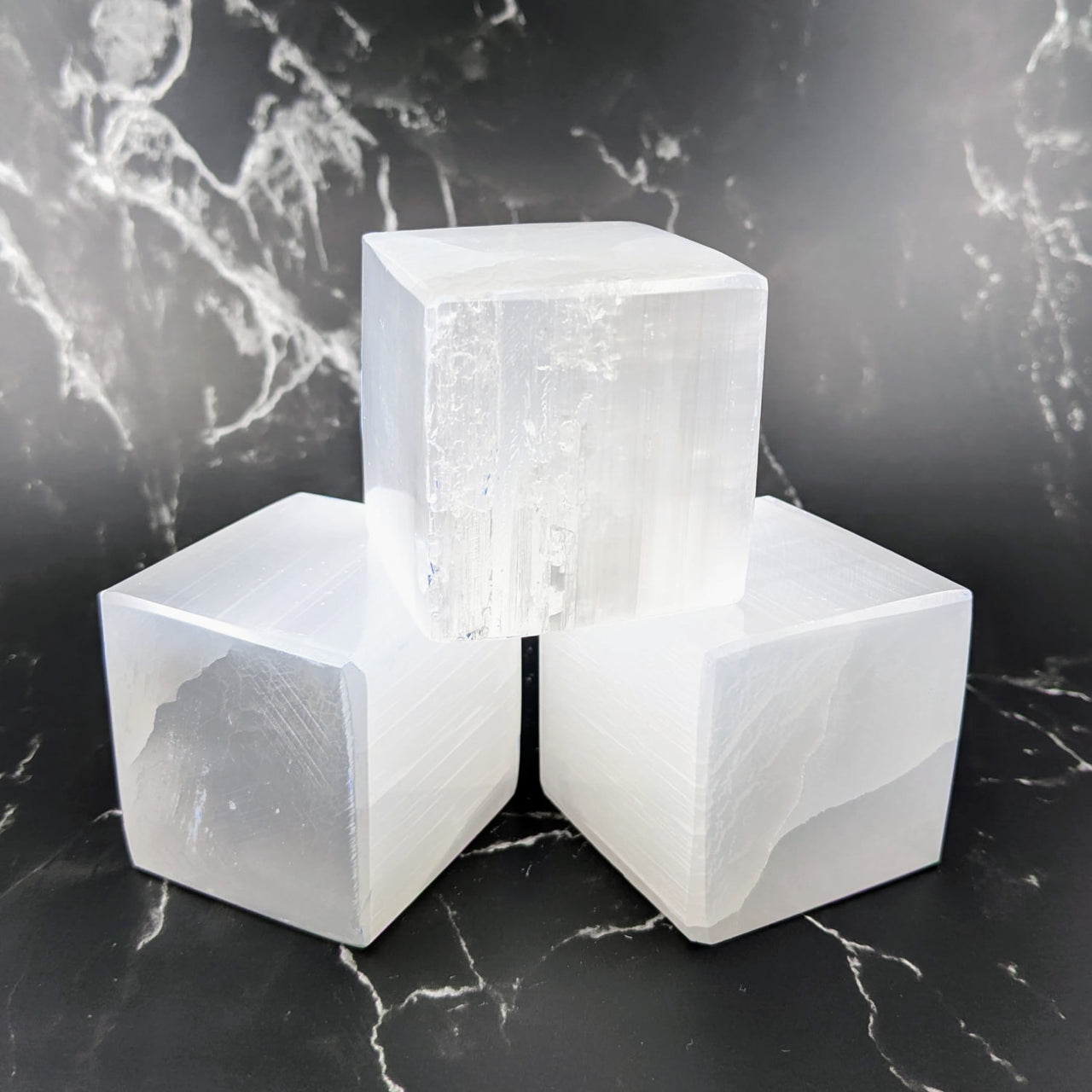 Three white selenite cubes on a marble surface - Selenite Cube Carving #Q170