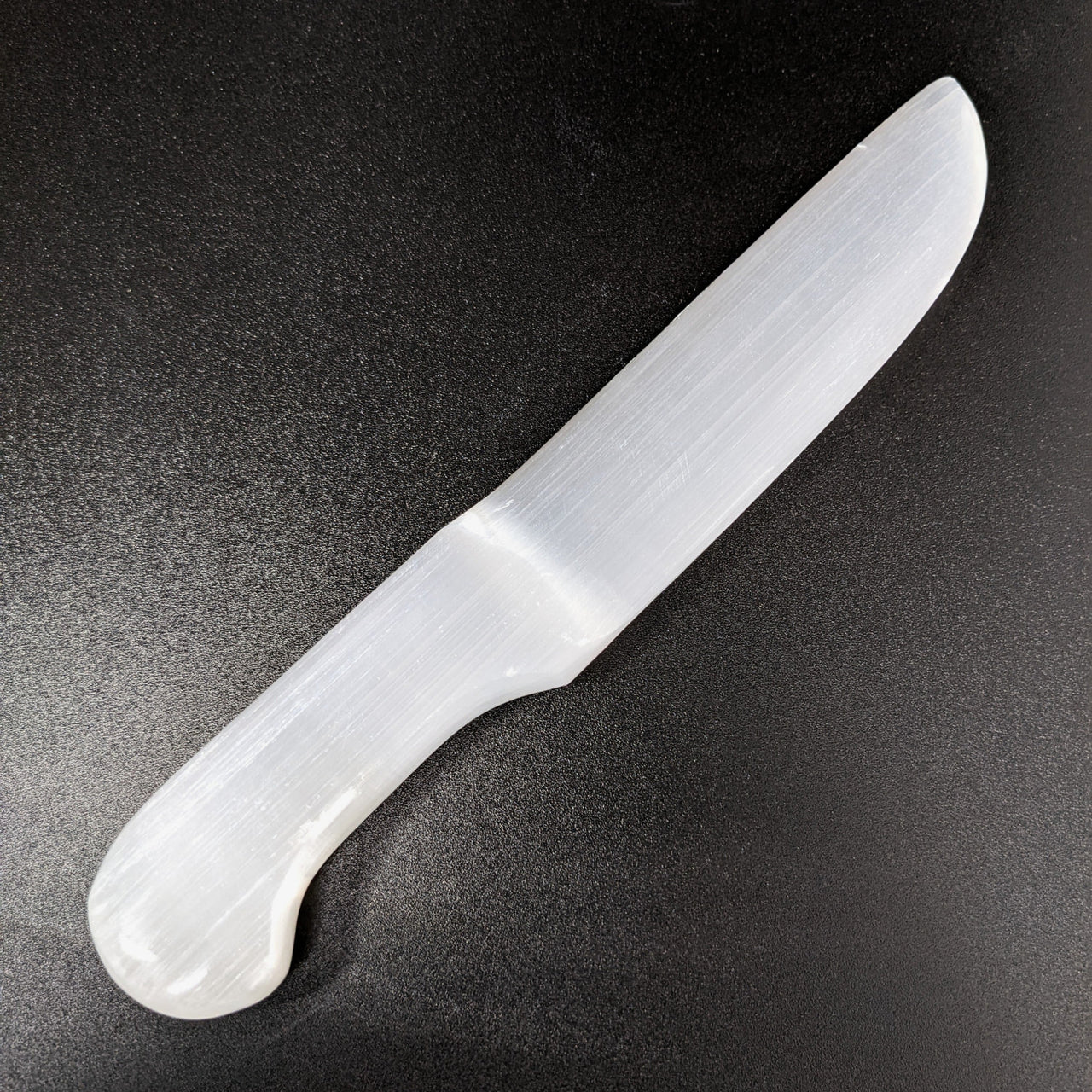 White Jade Selenite Dagger Knife for Cleansing and Cutting Cords on Black Background