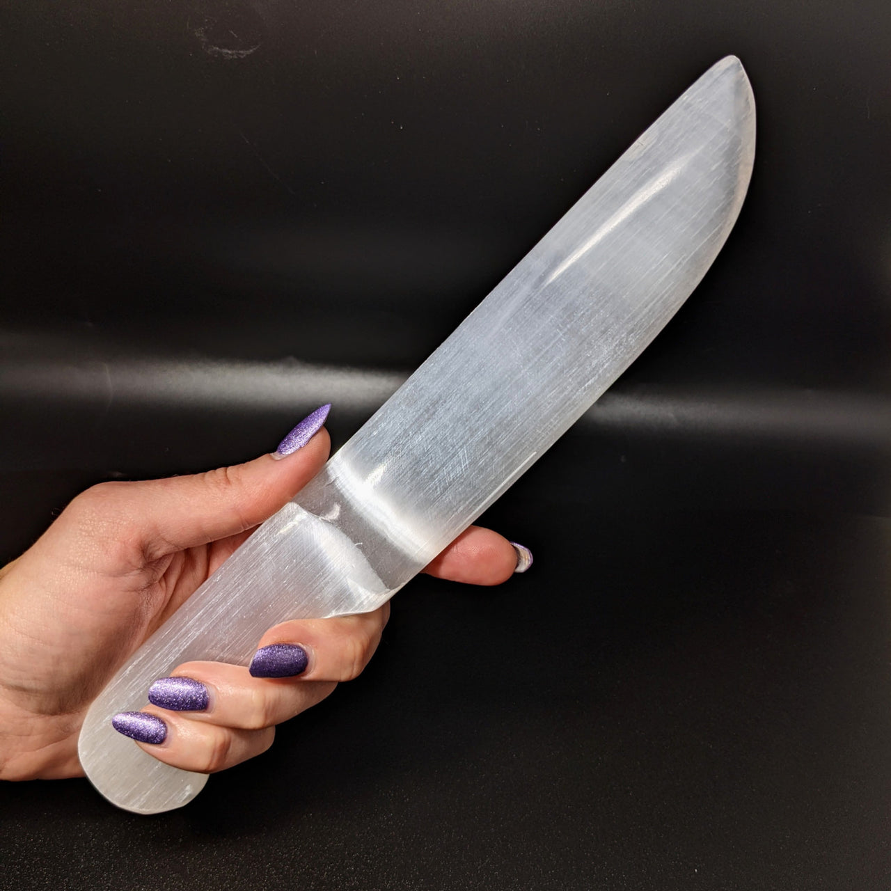 Woman holding a Selenite Dagger Knife for Cleansing and Cutting Cords, 10 inches