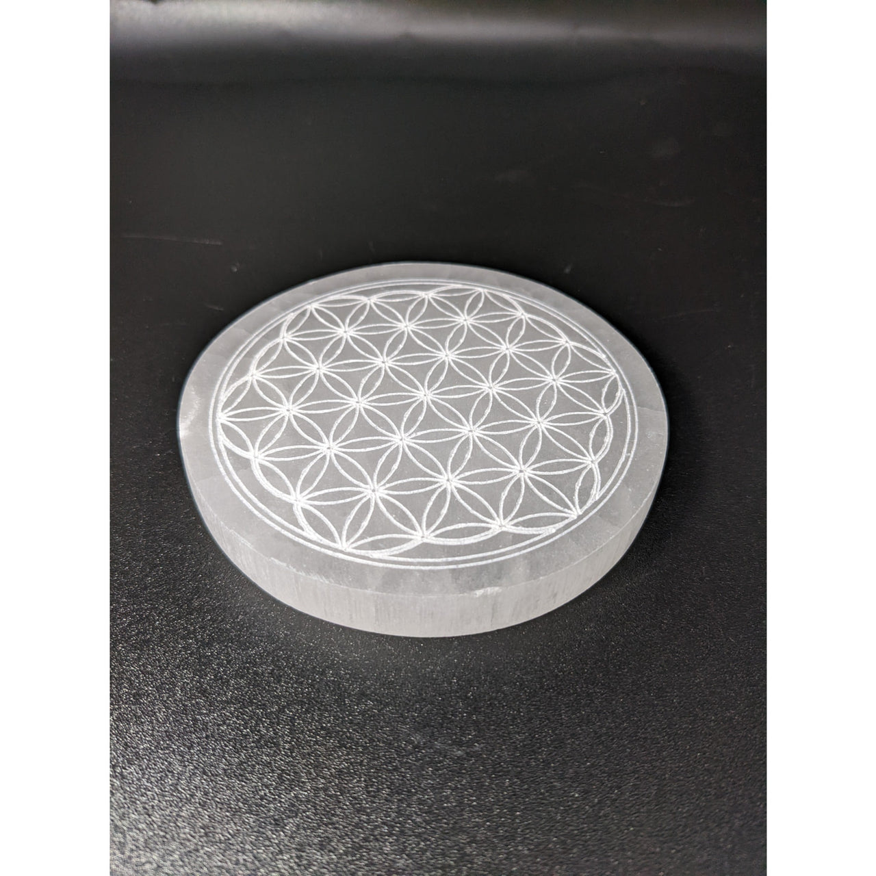 Selenite etched Flower of Life symbol on car dashboard, charging plate SKU #SK7585