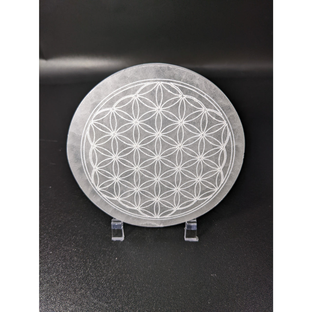 Selenite Etched Flower of Life Round Charging Plate #SK7585 on black surface