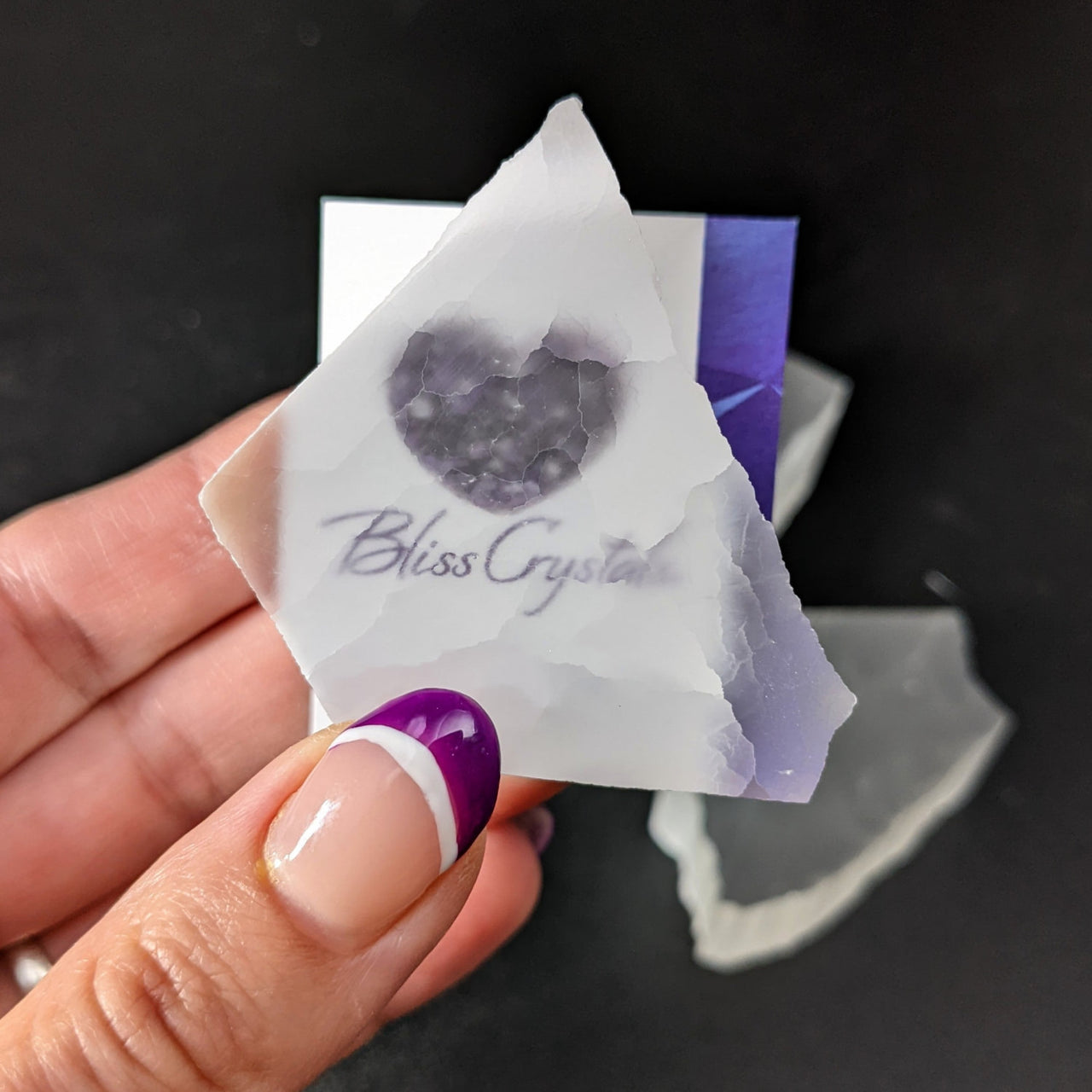 Hand holding paper with heart next to Selenite TV Rock Rough - Choose Size #SK8746