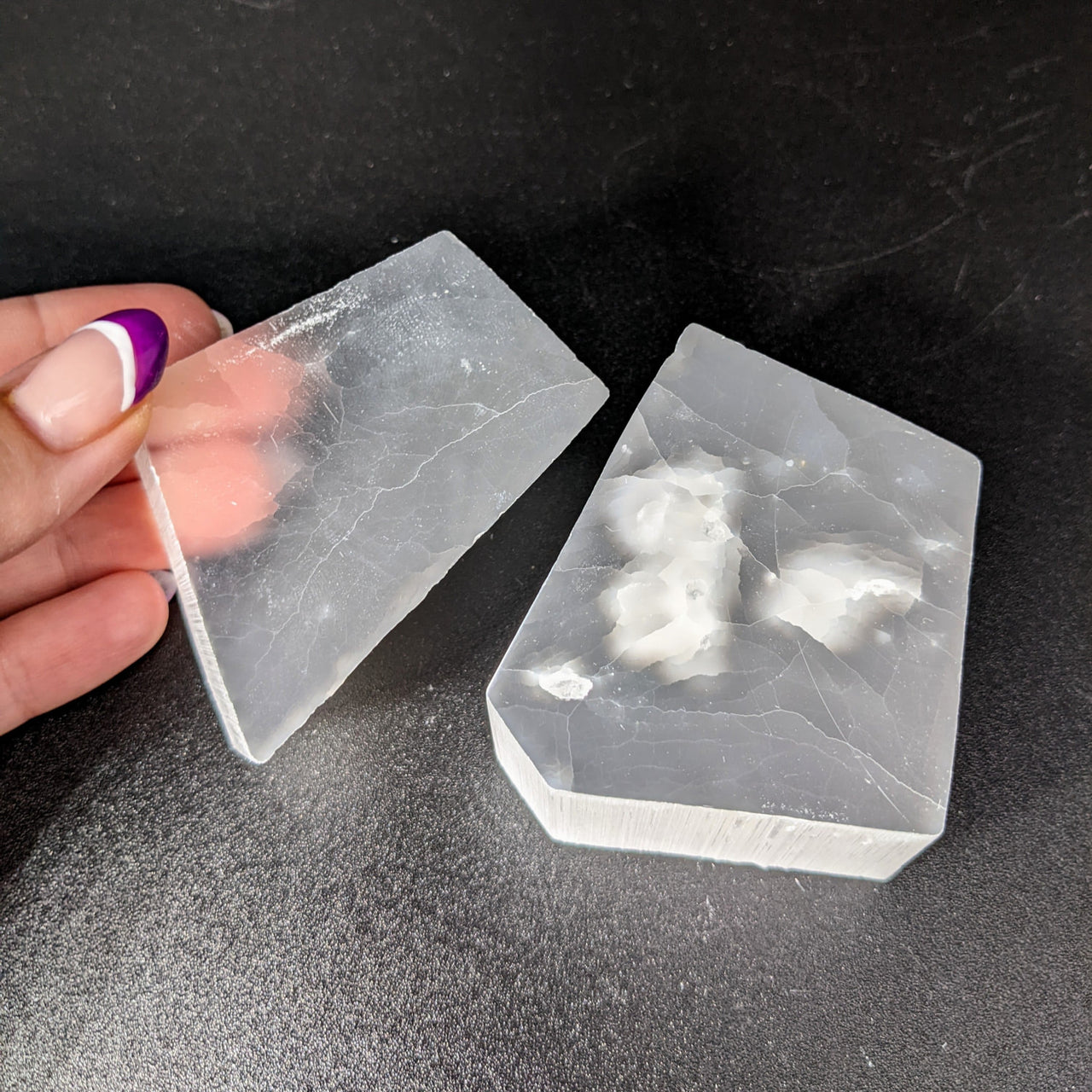 Hand holding plastic container of ice for Selenite TV Rock Rough product #SK8746