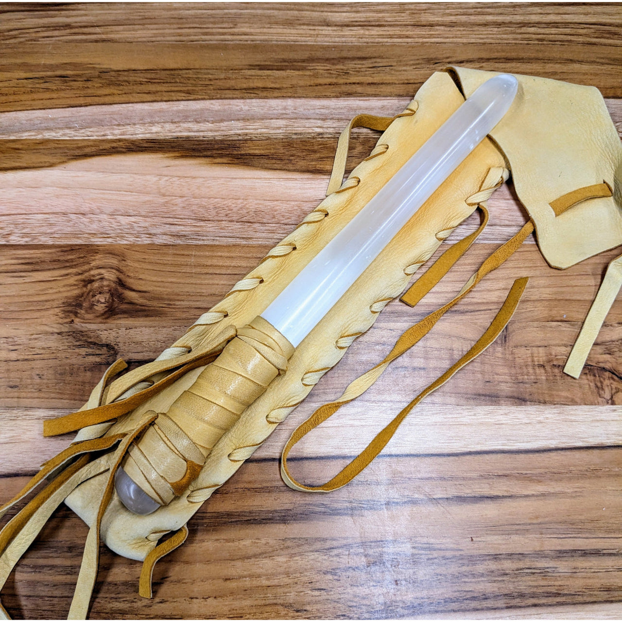 Shaman Selenite Wand with Deerskin Leather Handle and Pouch on Wooden Table