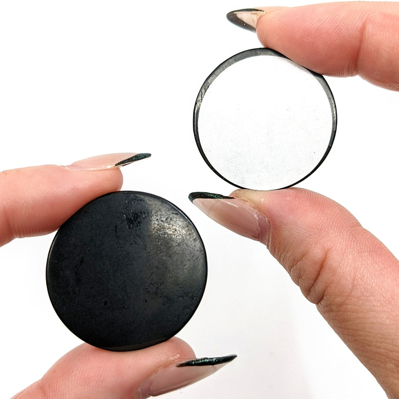 Person holding Shungite Round 1.2’ Adhesive Disc (4g) #SK9261 in their hand