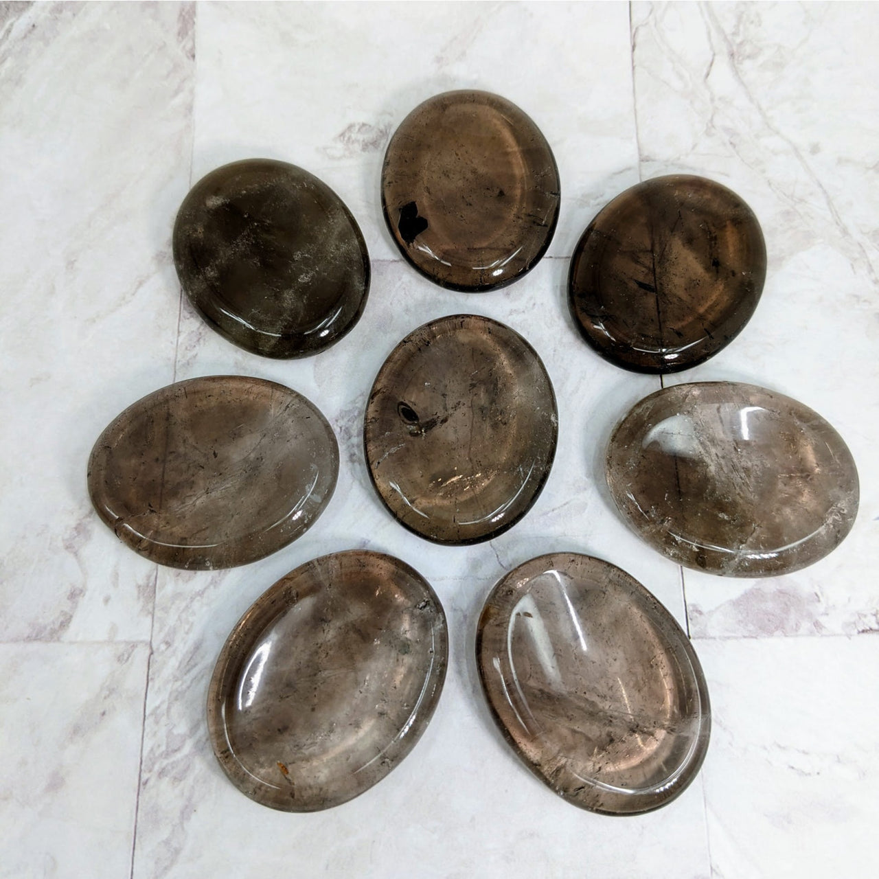 Six glass bowls with a white marble background featuring Smoky Quartz Thumb Stone #LV2265