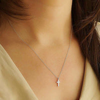 Thumbnail for Woman wearing a sterling silver charm necklace with cross pendant from product #J033