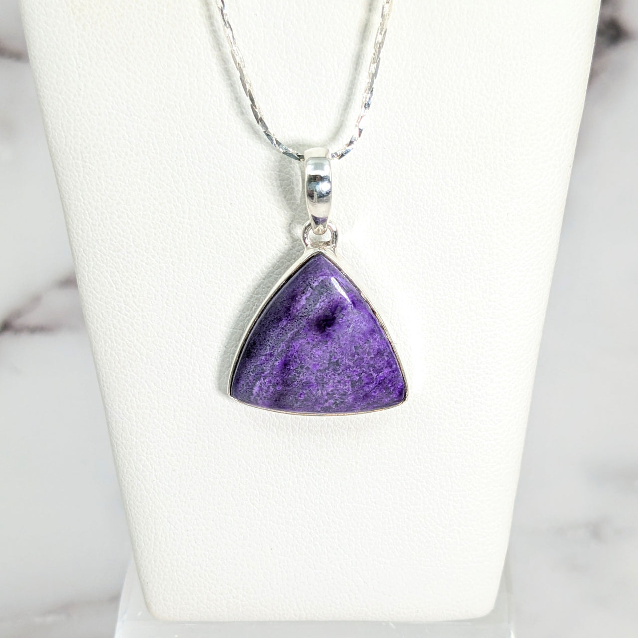 Sugilite 0.75’ triangle pendant #LV2645 on a silver chain featuring a purple stone