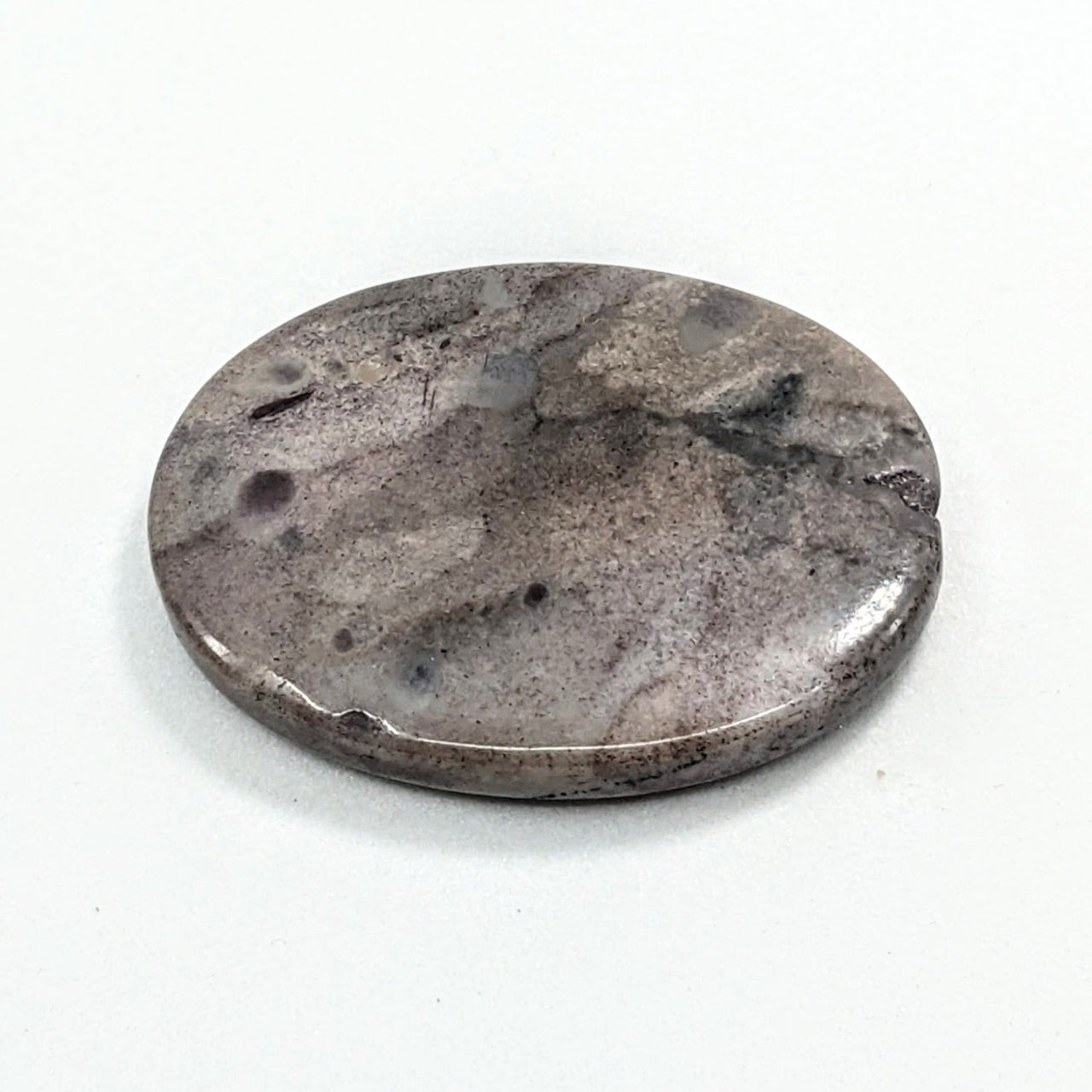 Sugilite Rectangle Cabochon #C138 featuring a round metal object on a white surface