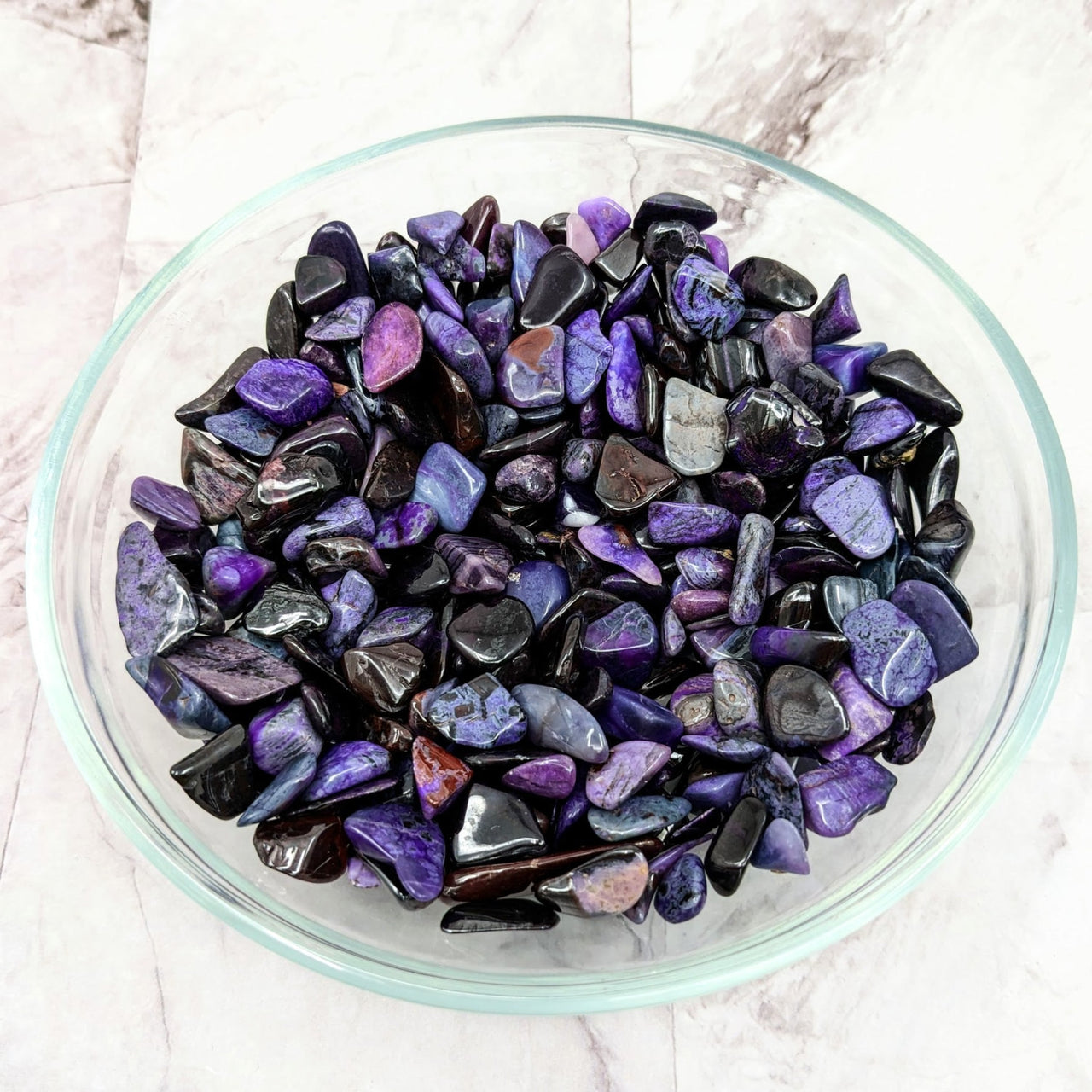 A bowl of Sugilite tumbled stones from a 6 stone parcel, vibrant purple and black crystals