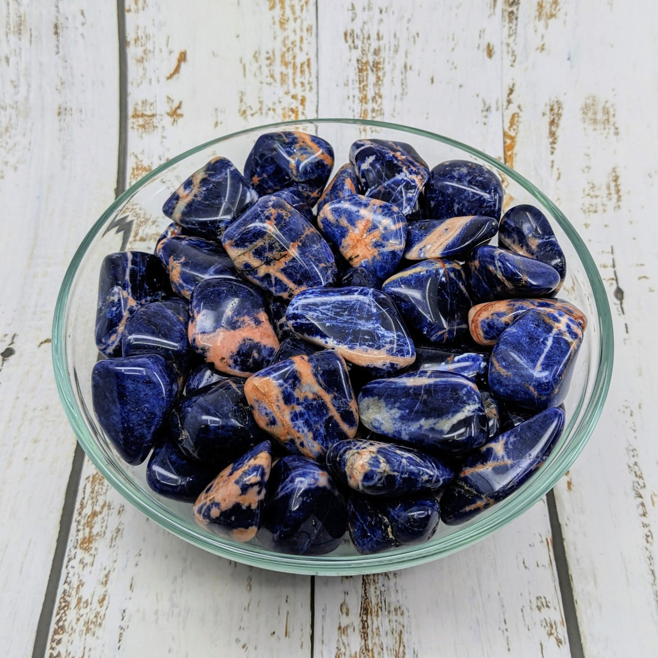 Bowl of blue and orange marble chips from the Sunset Sodalite Tumble #SK5894 collection