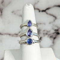 Thumbnail for Blue and white sapphire gems displayed on a marble backdrop for Tanzanite Faceted SS Ring