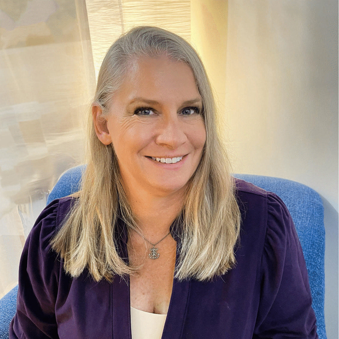 A woman with blonde hair in a purple shirt, spiritual guide for Tarot/Oracle Card Reading session