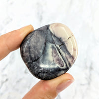 Thumbnail for Hand holding a Tiffany Stone palm stone in black and white marble pattern #LV2019