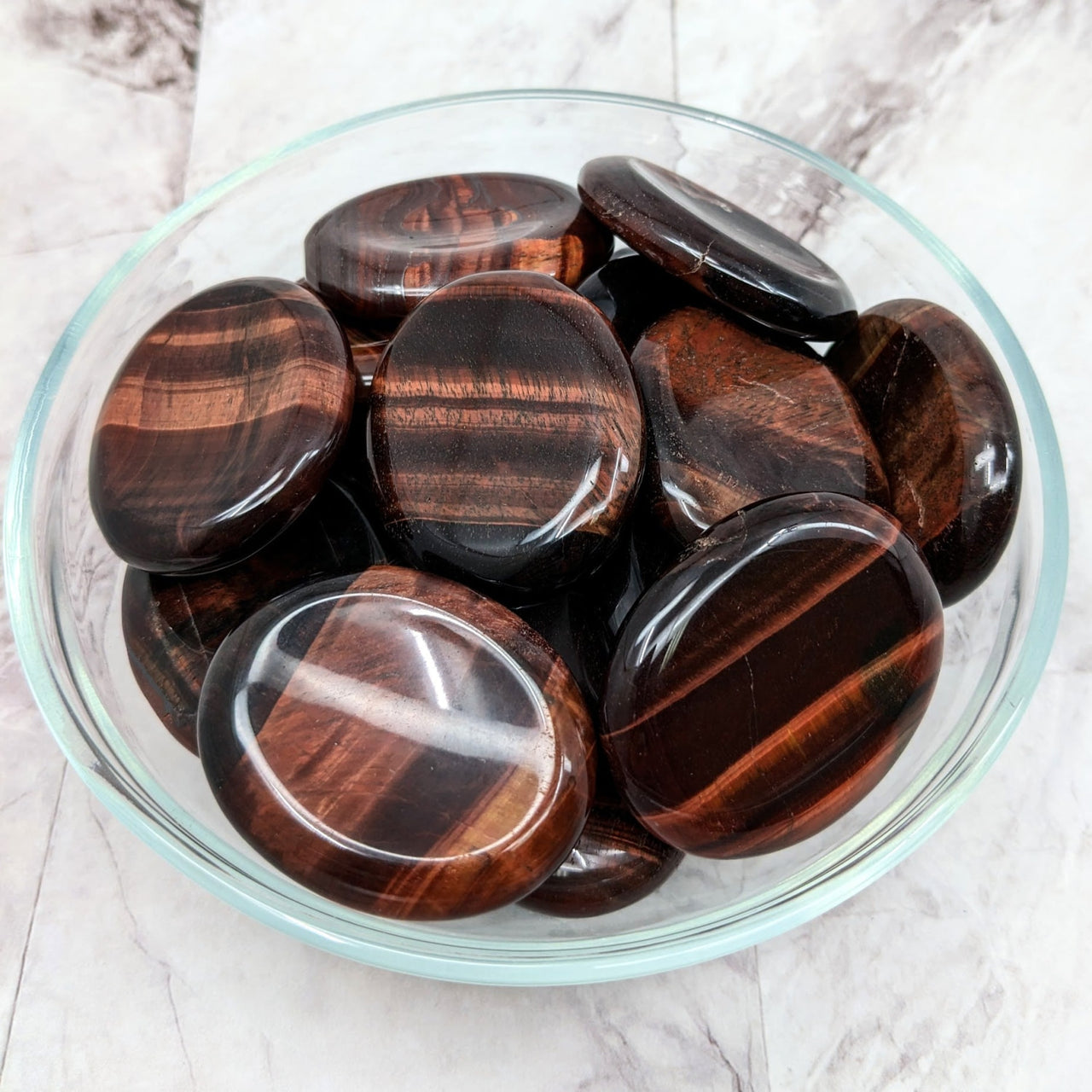 Tiger’s Eye red thumb stones in a bowl, perfect for healing and energy balance