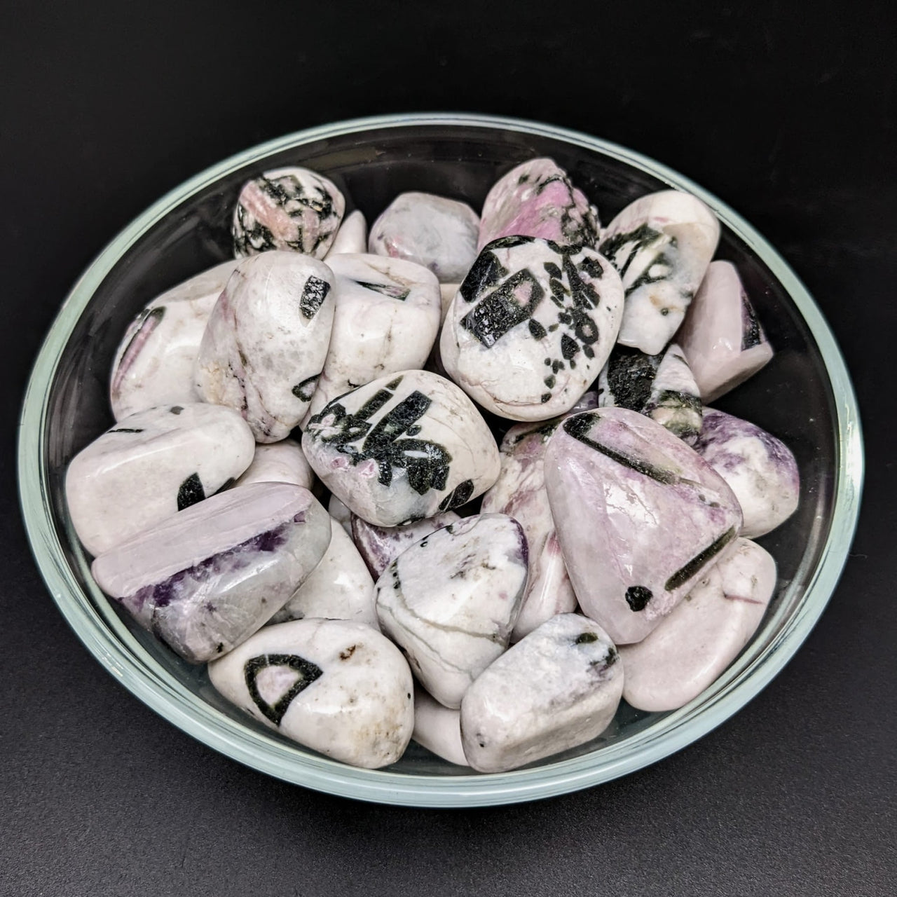 A bowl of tumbled stones showcasing Tourmaline Conglomerate with Lepidolite, Green, and Pink