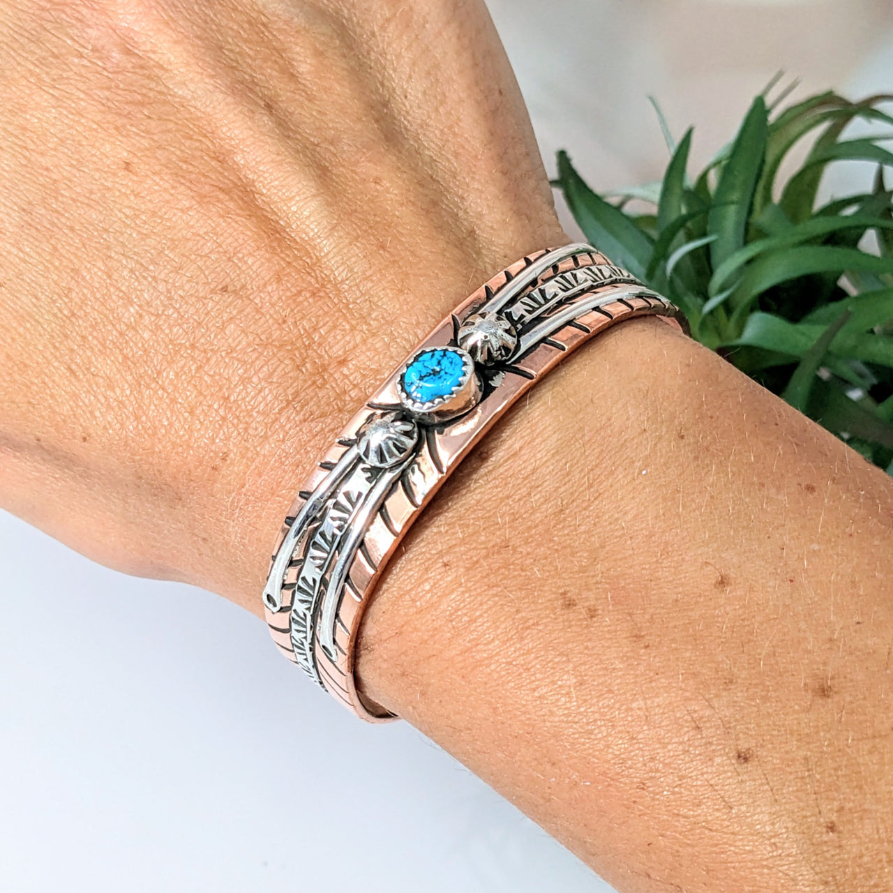 Close-up of a woman’s hand wearing the Turquoise Cuff 2.5’ Copper and Silver Bracelet #LV2766