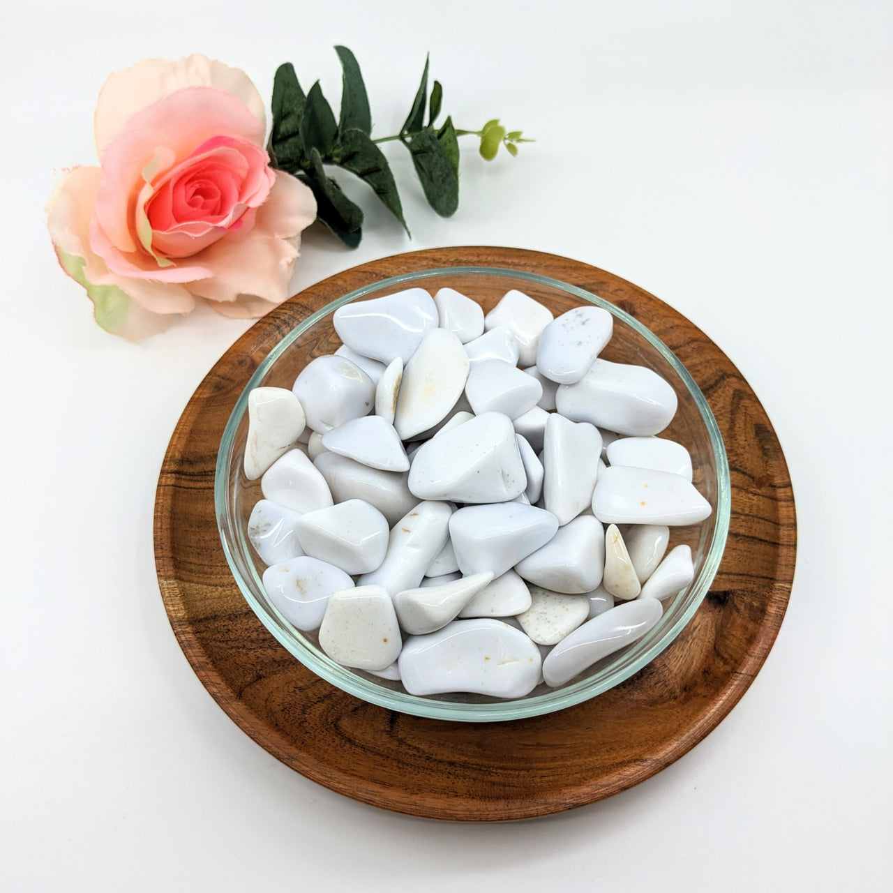 White Chalcedony tumbled stones in heart shapes on a wooden plate, product #LV3072